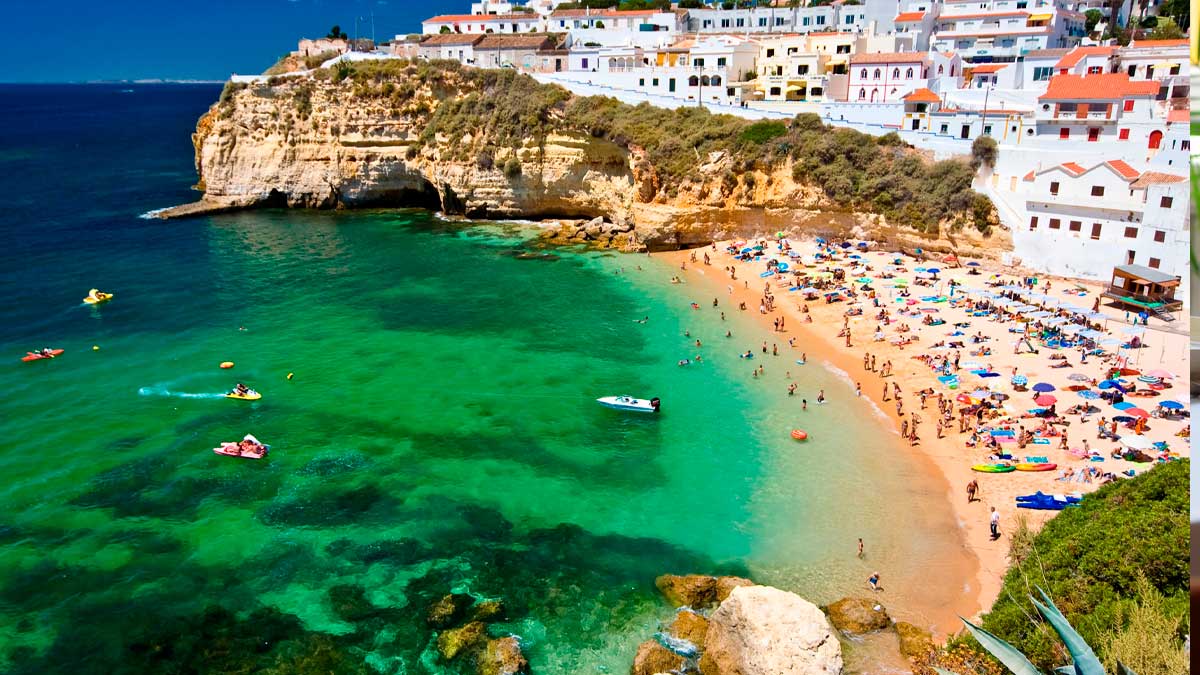 Playa andaluza con alta afluencia de bañistas y agua cristalina durante Semana Santa