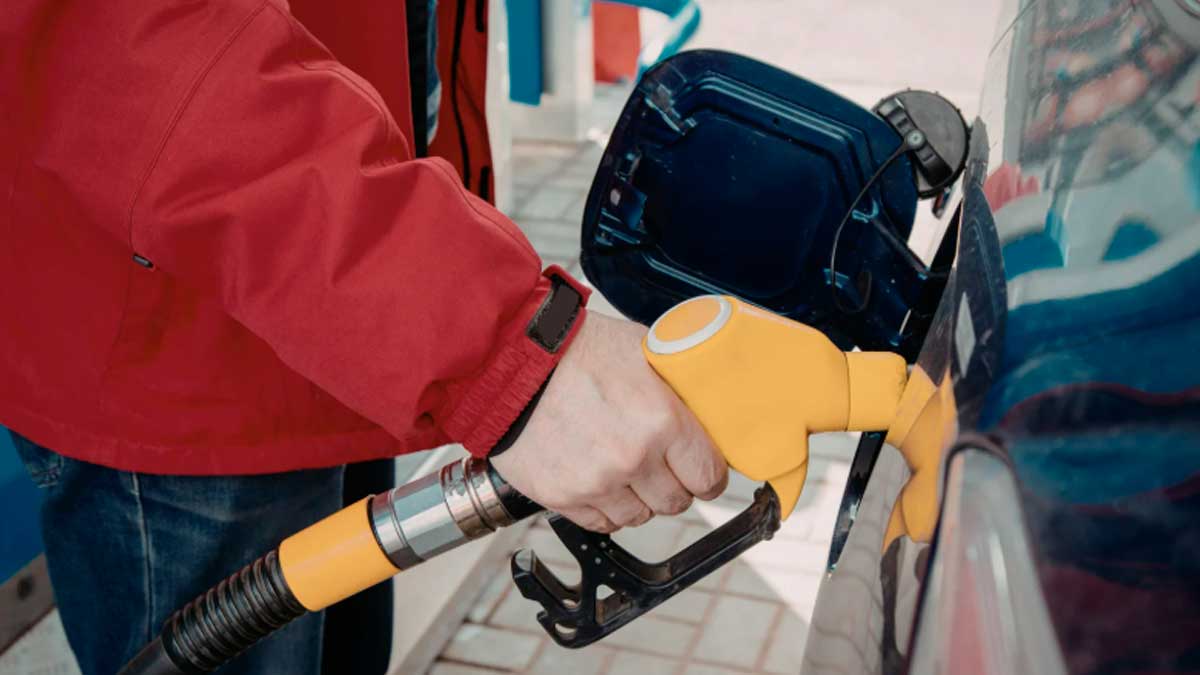 Persona repostando gasolina en un coche durante Semana Santa para ahorrar en combustible según recomendación de la OCU