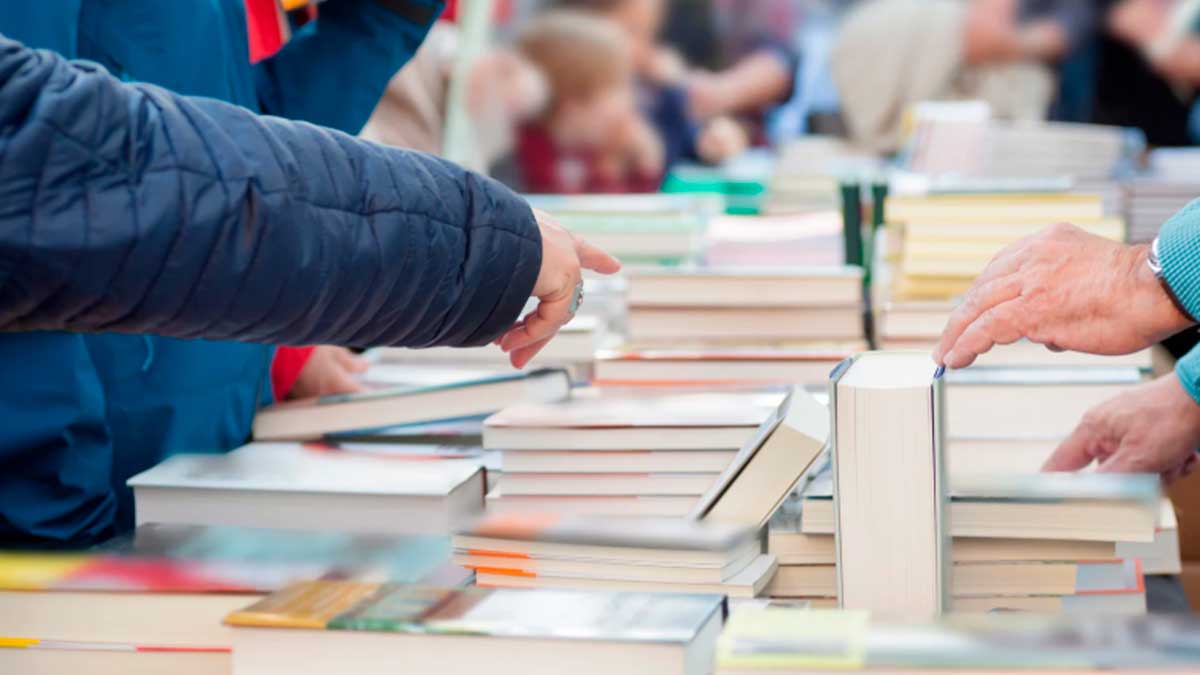 Personas hojeando y comprando libros en una feria por el Día del Libro en Andalucía