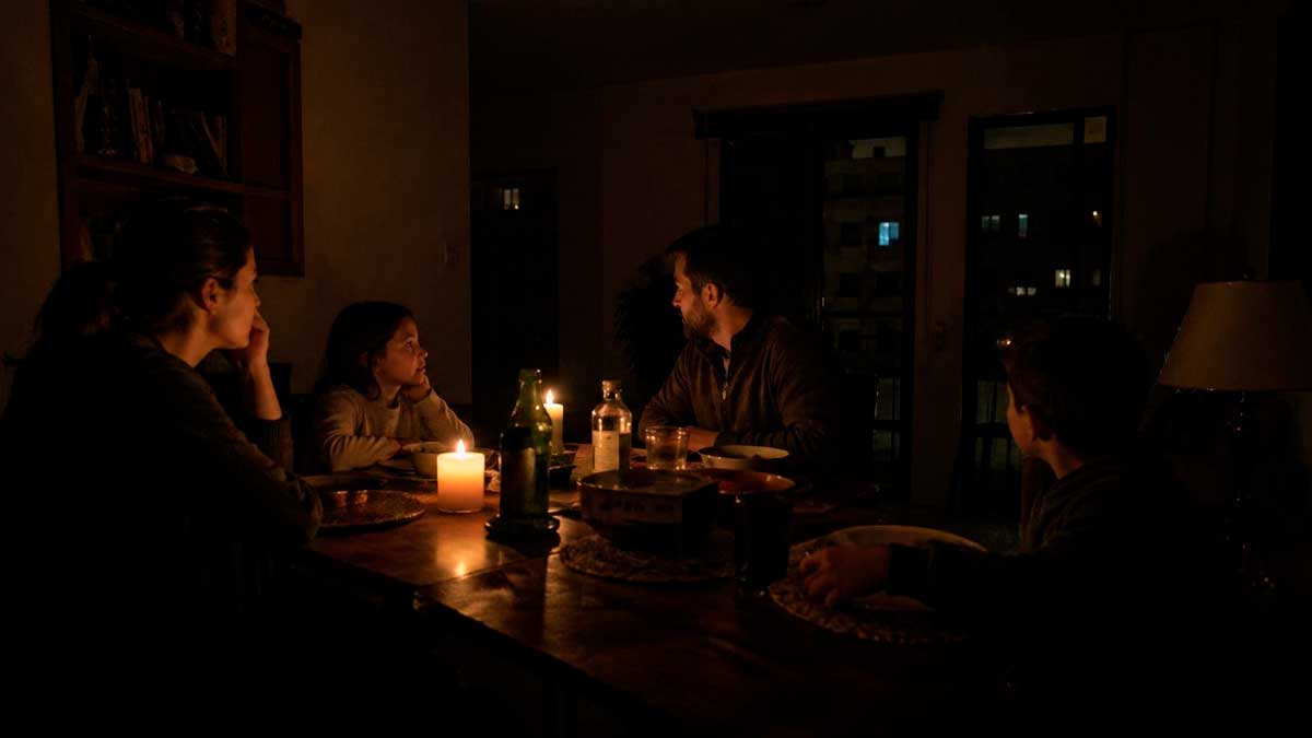 Familia cenando a la luz de velas durante un apagón en España tras corte eléctrico prolongado