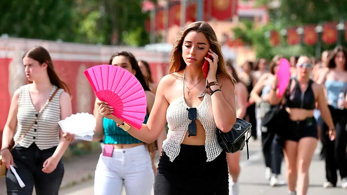 Personas caminando con abanicos durante un episodio de calor en Andalucía con altas temperaturas