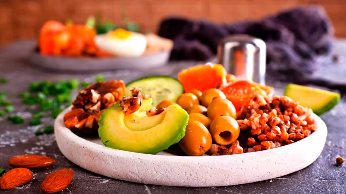 Plato saludable con aguacate frutos secos aceitunas y verduras dieta mediterránea para aumentar la esperanza de vida