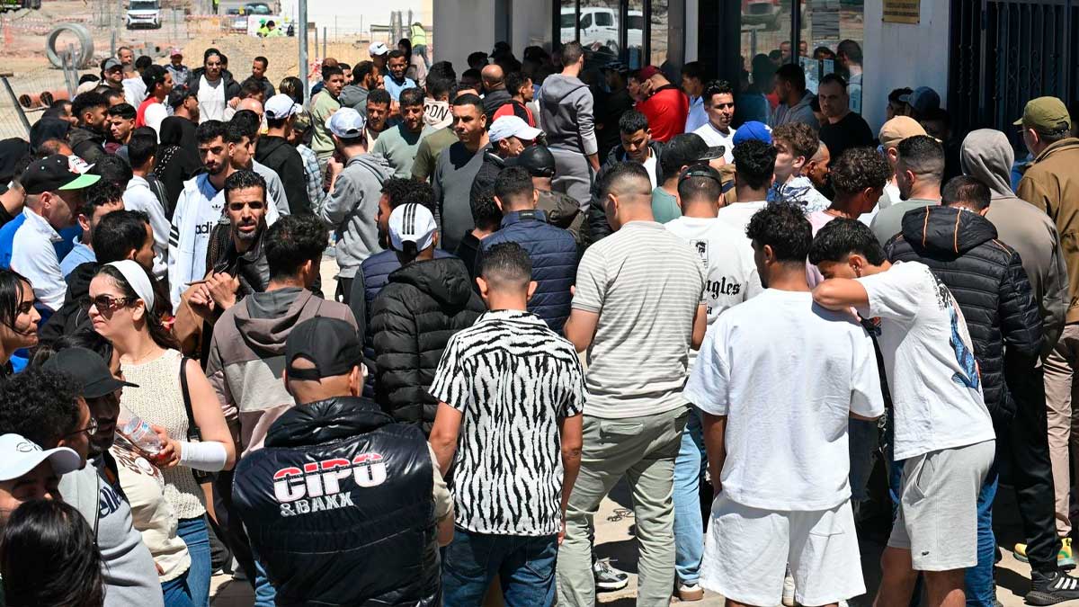 Cola de inmigrantes esperando para realizar trámites de regularización en España