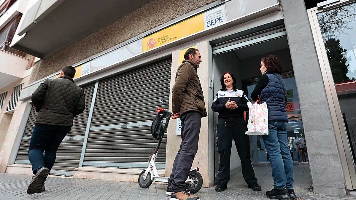 Personas en la entrada de una oficina del SEPE consultando trámites sobre paro y alta como autónomo en España