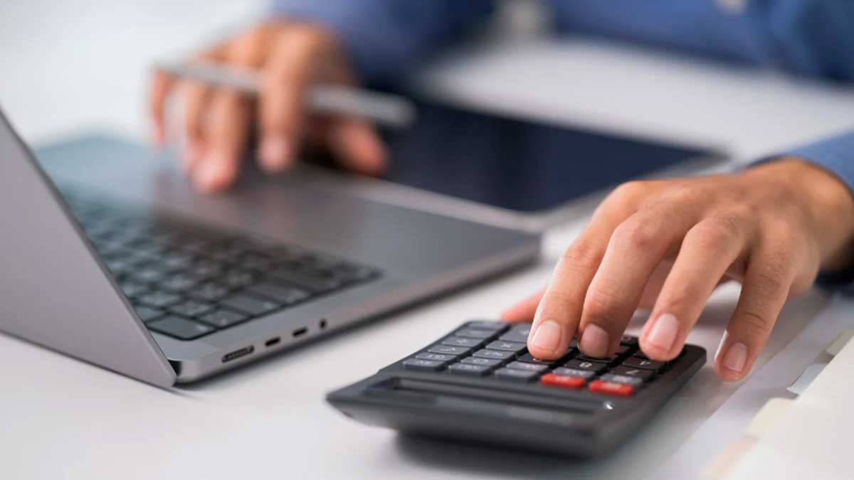 Persona calculando gastos en portátil y calculadora para declarar la compra de vivienda en la renta
