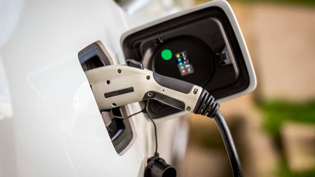 Cargando coche eléctrico en punto de recarga doméstico para beneficiarse de deducción fiscal