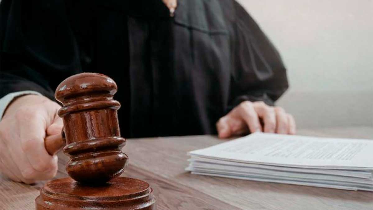 Juez con mazo y documentos en sentencia por despido improcedente por retrasos laborales