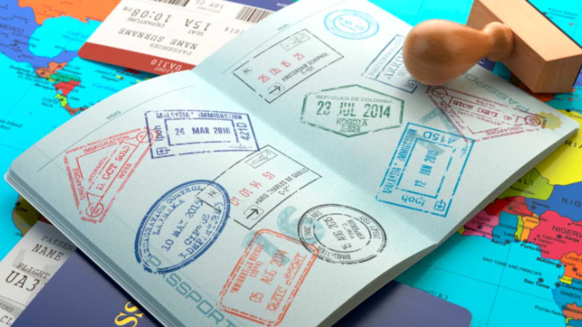 Pasaporte abierto con sellos de entrada y salida sobre mapa del mundo antes de un viaje