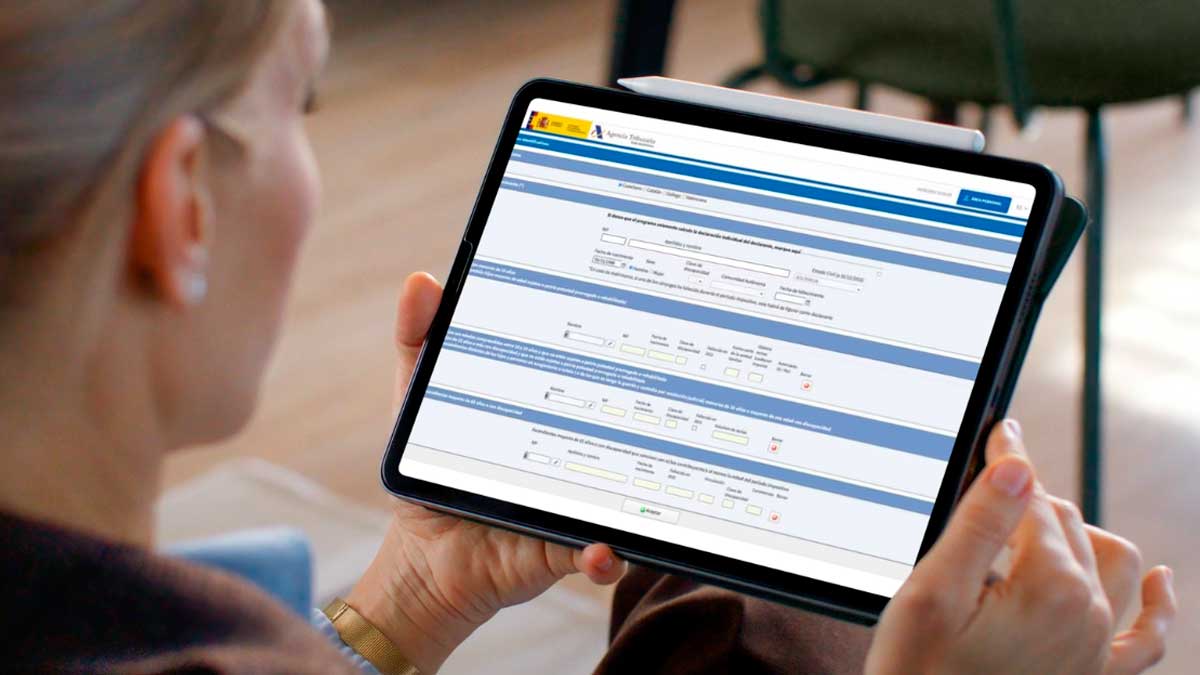 Mujer revisando el borrador de la Renta 2025 en una tablet con formulario de la Agencia Tributaria