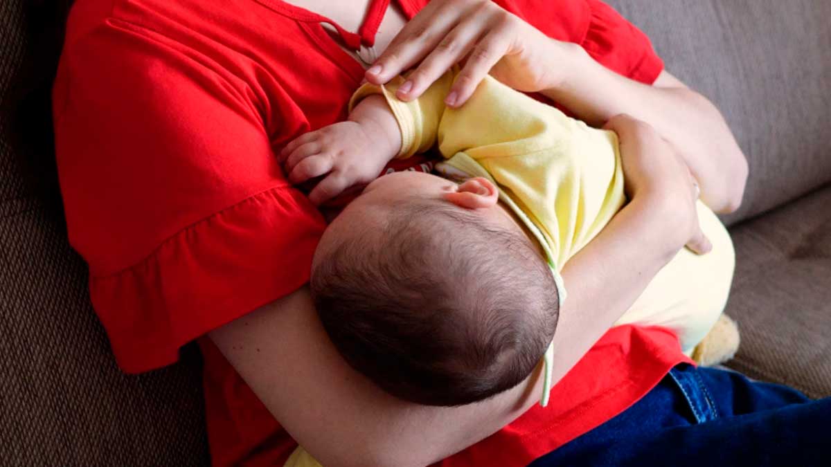 Madre con bebé en brazos relacionada con deducción por maternidad en la declaración de la renta