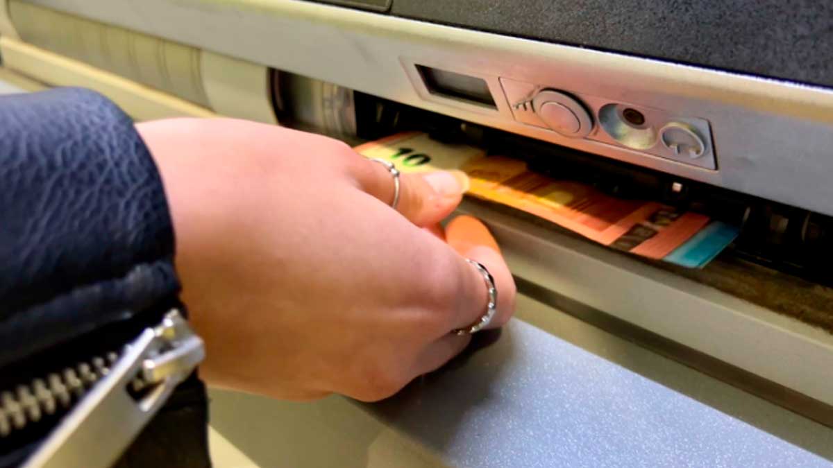 Persona retirando dinero en efectivo de un cajero automático bajo control de Hacienda