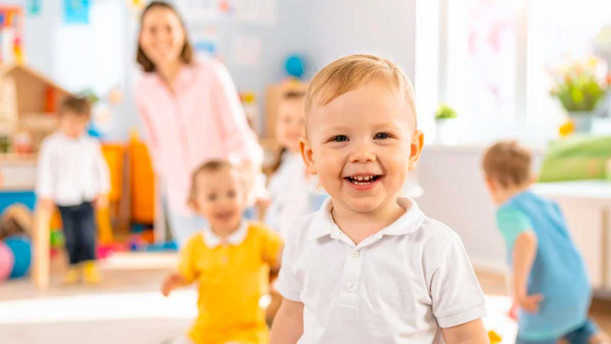 Niños pequeños jugando en escuela infantil con educadora durante el inicio del plazo de escolarización en Andalucía