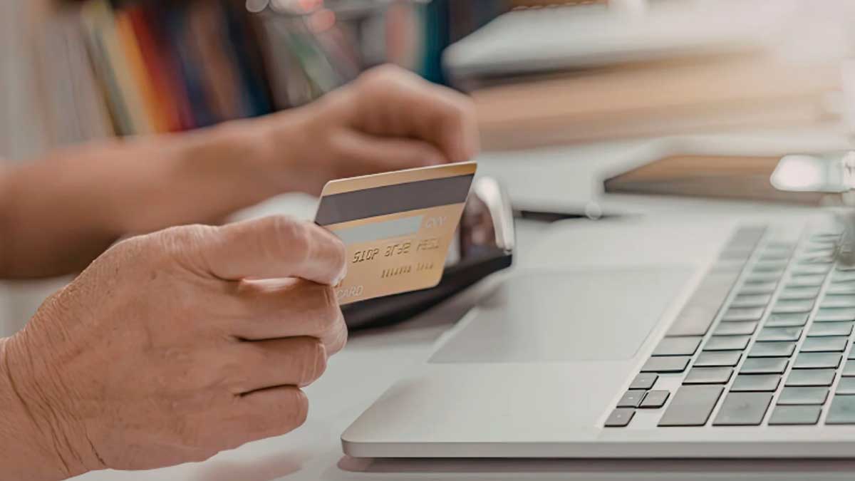 Persona pagando con tarjeta en un portátil durante una compra online segura