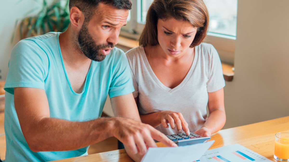 Pareja revisando factura del gas con calculadora tras la bajada de la tarifa regulada en abril