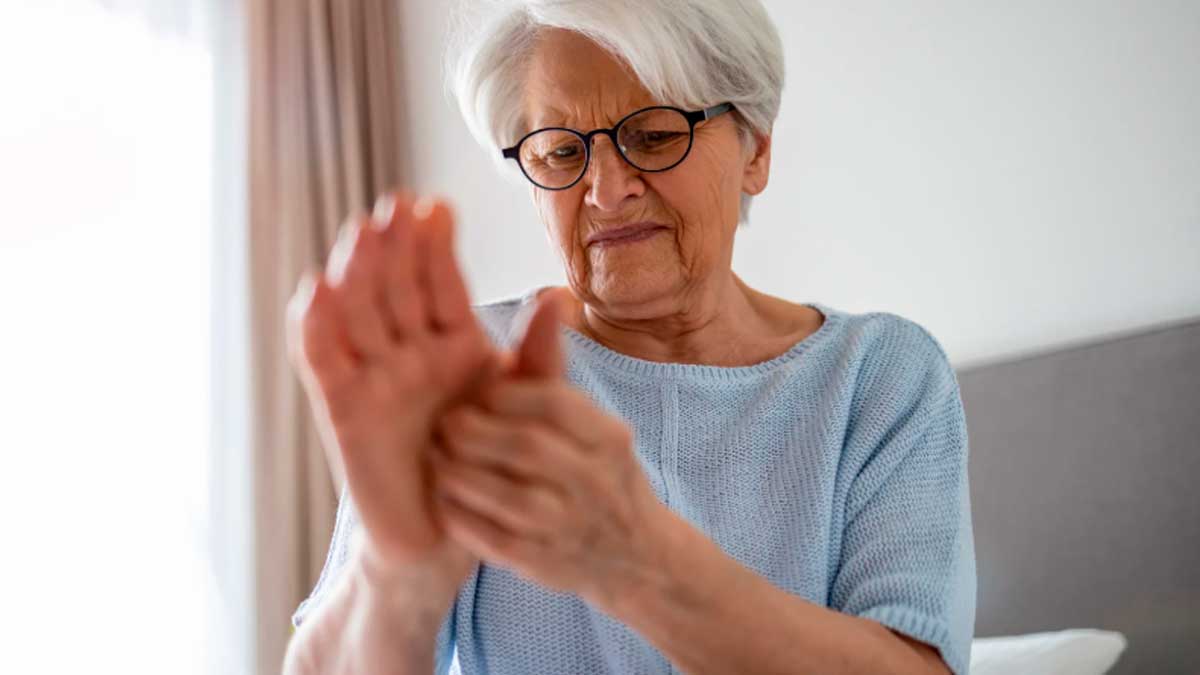 Mujer mayor con artritis reumatoide dolor en manos en casa