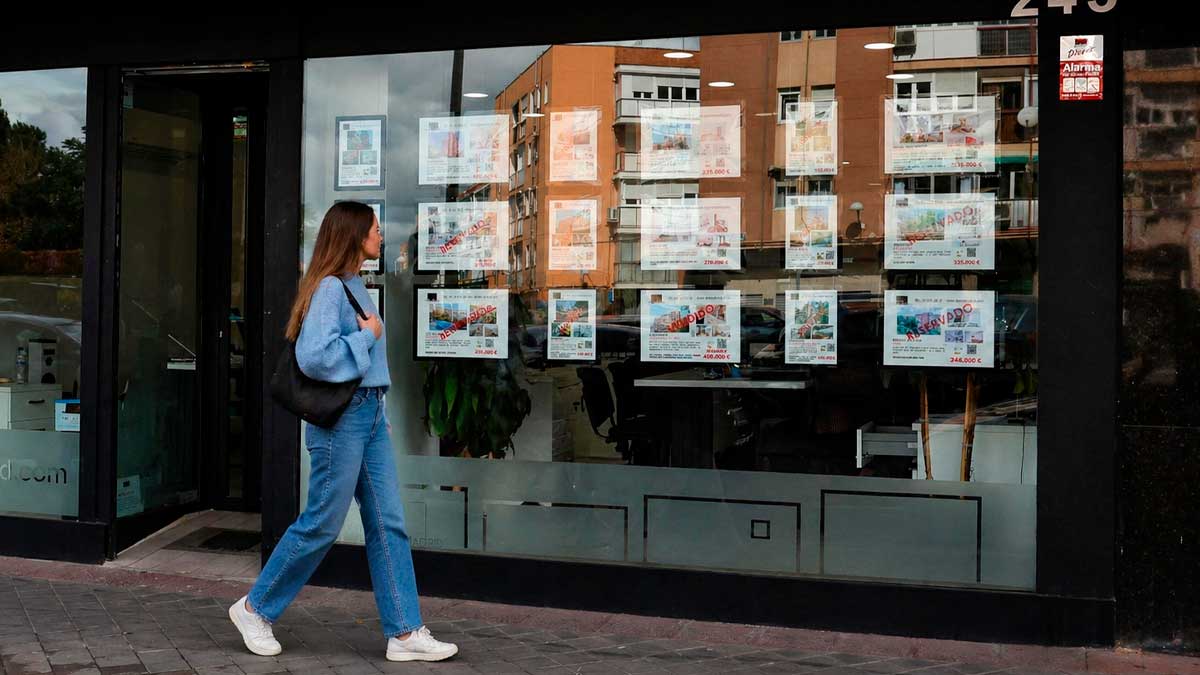 Mujer joven mirando anuncios de pisos en una inmobiliaria en Andalucía