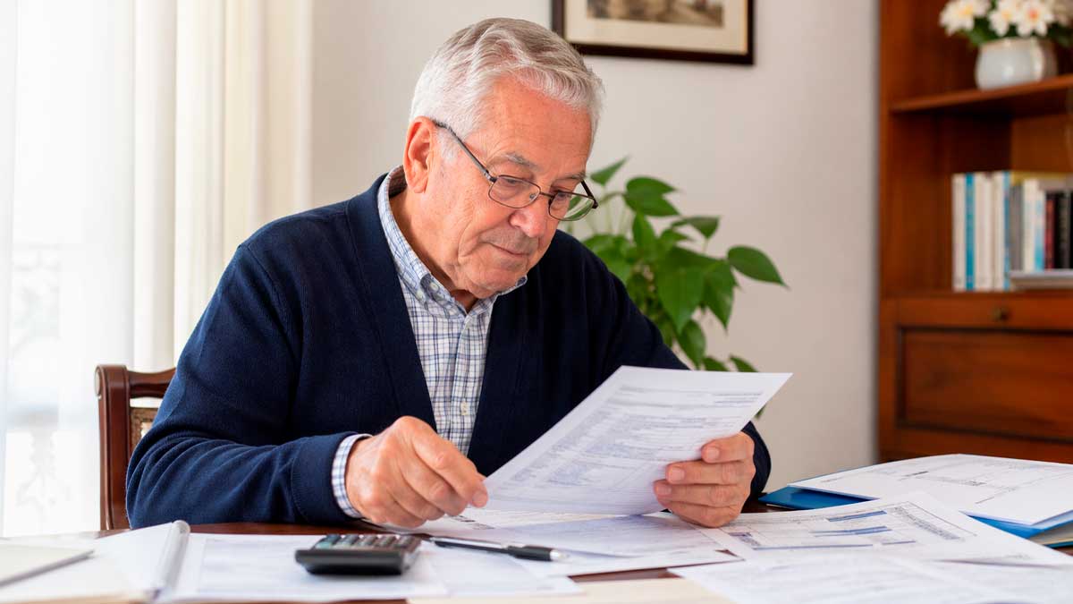 Persona mayor revisando documentos de la renta en Andalucía