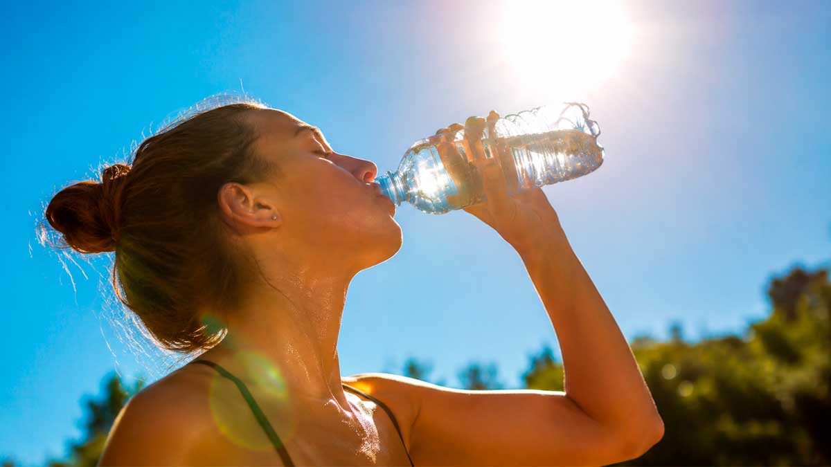 Mujer bebiendo agua bajo un intenso calor durante la ola de altas temperaturas en Andalucía