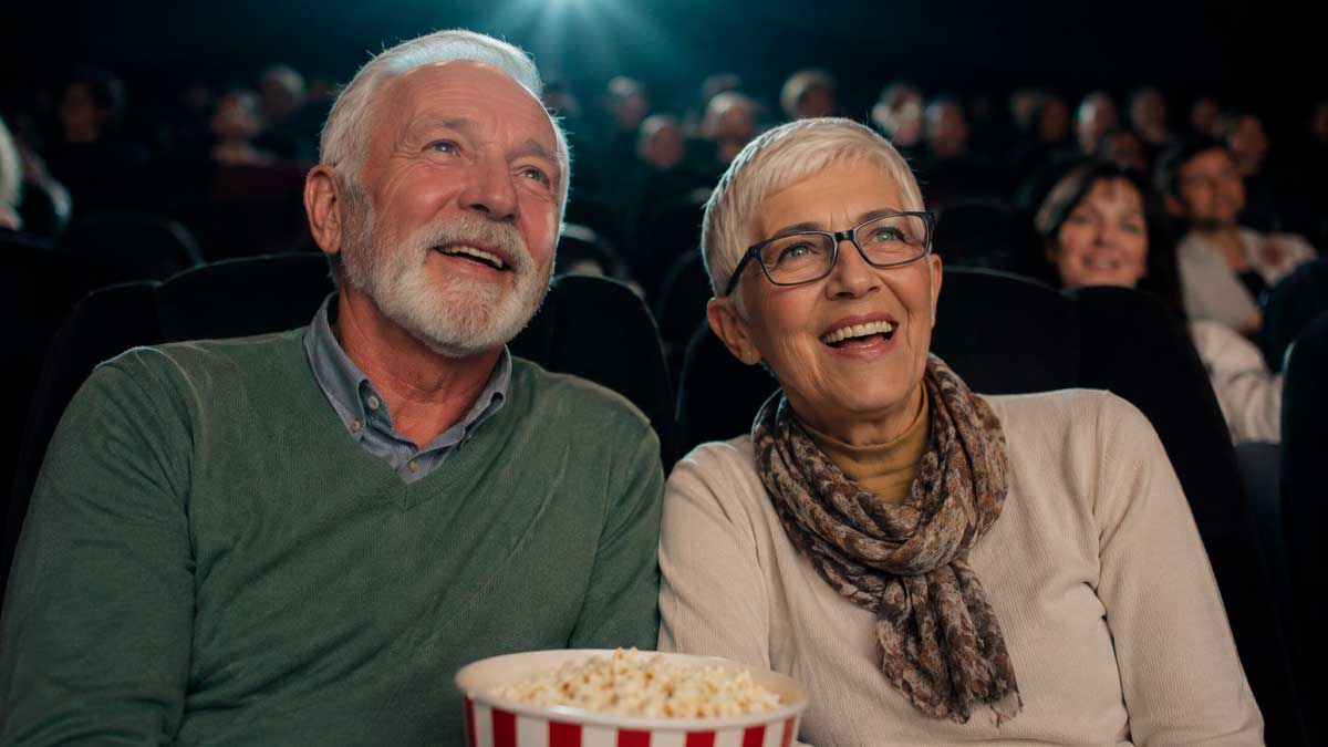 Dos personas mayores de 65 años viendo una película en el cine gracias al programa Cine Sénior