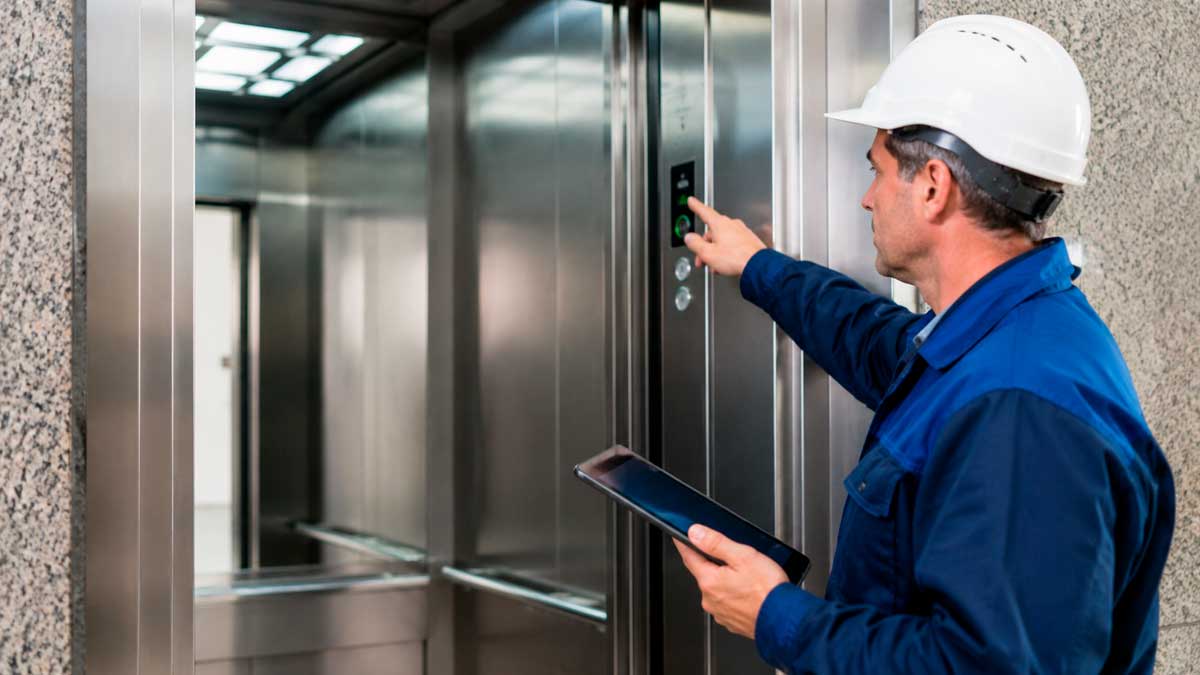 Técnico revisando un ascensor tras la nueva normativa de seguridad en comunidades de vecinos