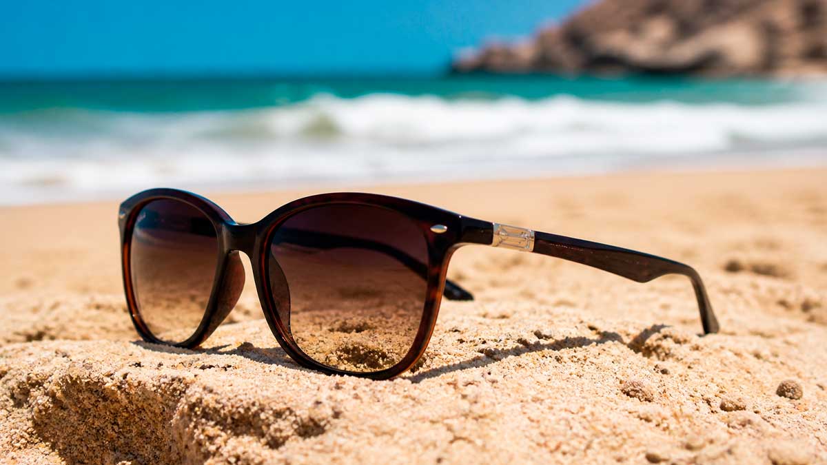 Gafas de sol sobre la arena en la playa ejemplo de protección ocular frente al riesgo de productos no homologados