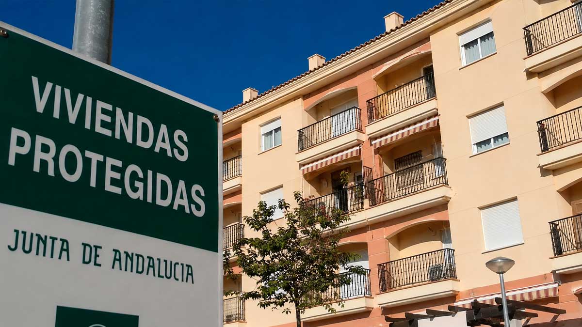 Edificio de viviendas protegidas en Andalucía con cartel informativo sobre VPO y regulación de precios