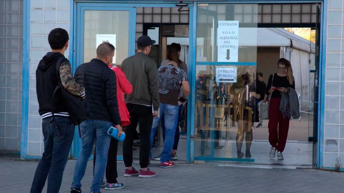 Personas haciendo cola en una oficina de extranjería para tramitar la regularización extraordinaria en España