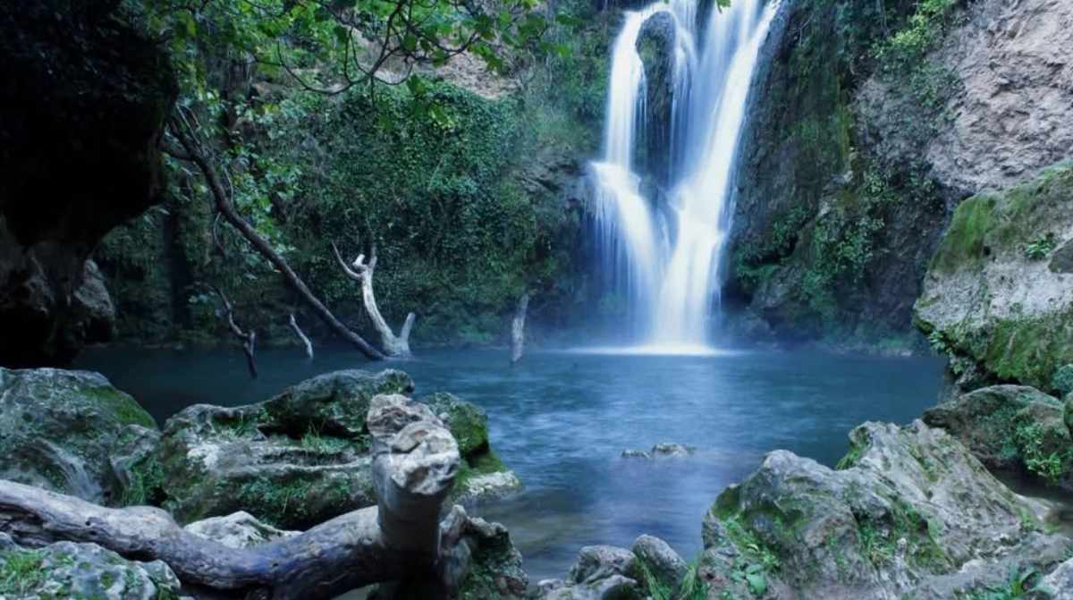 Cascada y poza natural en Sierra Morena de Sevilla rodeadas de vegetación