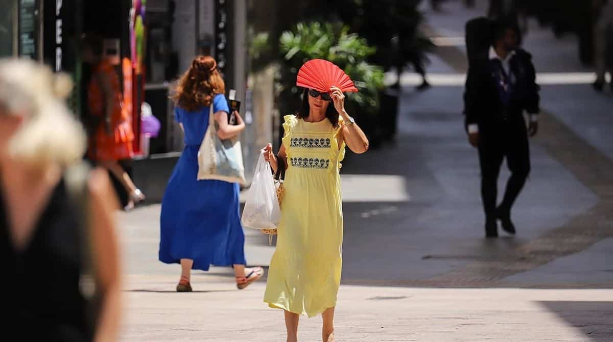 Persona se protege del calor con un abanico durante una jornada de altas temperaturas en Almería