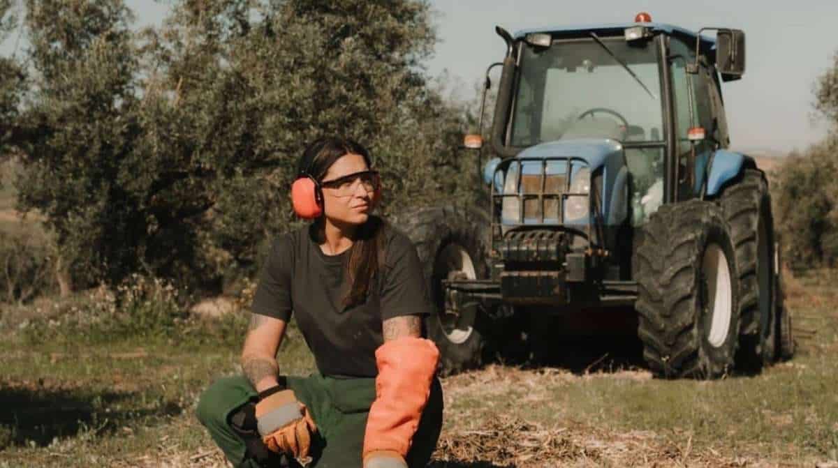 Agricultora junto a un tractor en una explotación agrícola de Andalucía