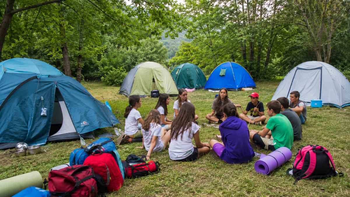 Campamento de verano en Andalucía con jóvenes realizando actividades al aire libre en una zona de acampada