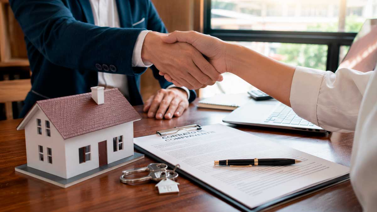 Compra de una vivienda en Andalucía: apretón de manos tras firma de contrato inmobiliario