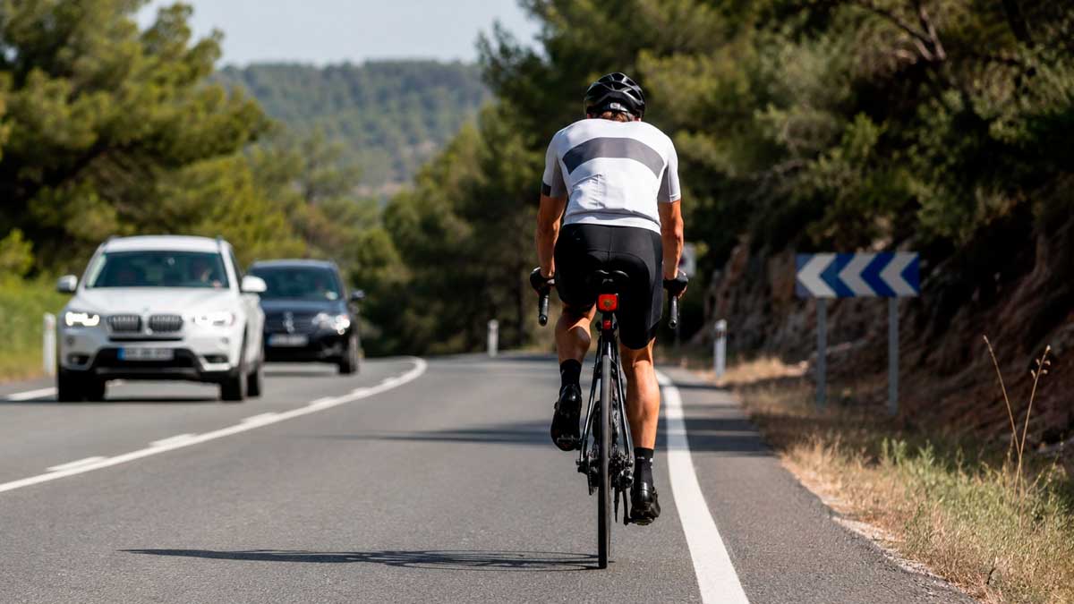 Ciclista circulando por carretera mientras la DGT recuerda normas básicas de seguridad vial