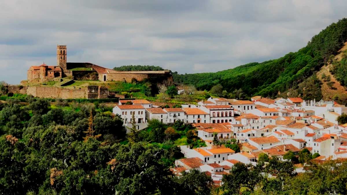 Vista panorámica de la Sierra de Huelva con su castillo y casas blancas, destino de turismo gastronómico sostenible.