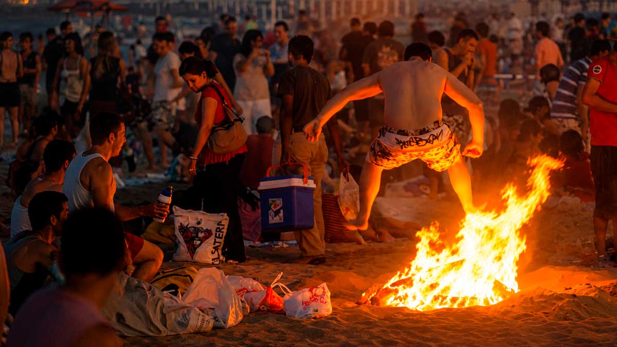 Personas celebrando San Juan con hogueras en la playa de Cádiz