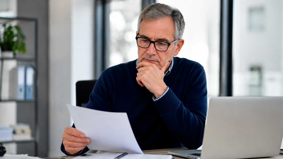 Hombre mayor de 52 años revisando documentos mientras busca empleo tras cobrar el subsidio del SEPE