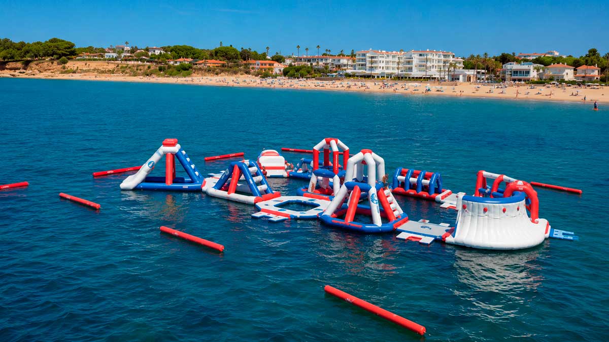 Parque acuático flotante en La Barrosa con hinchables sobre el mar