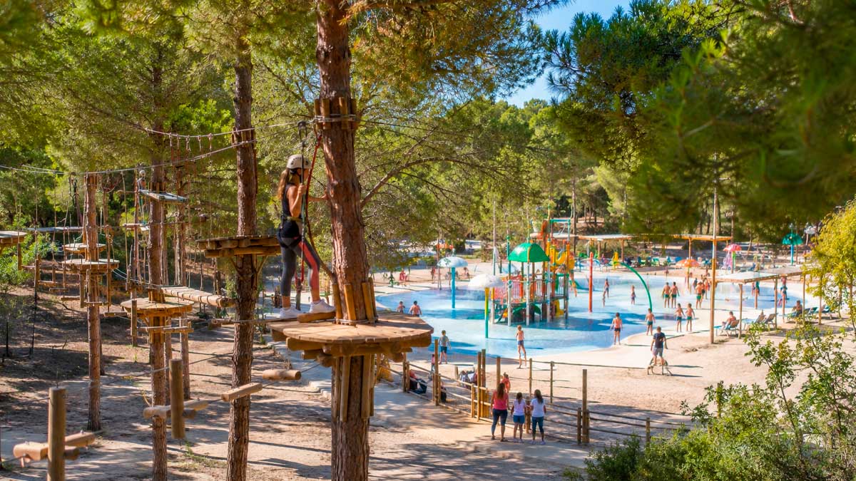Parque de aventuras en entorno natural con circuitos entre árboles, tirolinas y zona acuática tipo Splash Park en Punta Umbría.