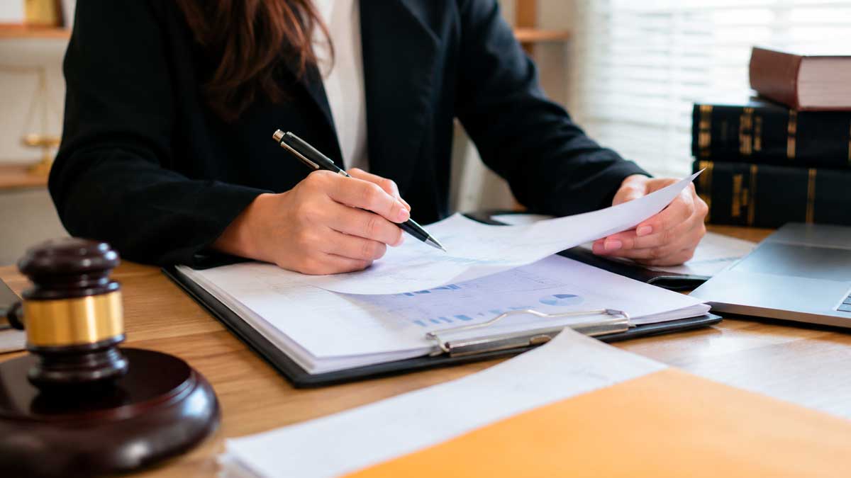 Trabajadora revisando documentación laboral en una oficina durante una investigación por fraude en prestaciones por desempleo