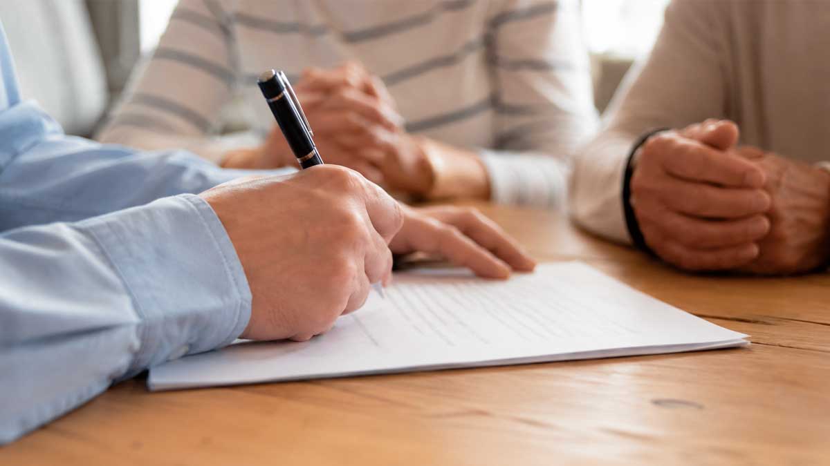Persona firmando un documento relacionado con el testamento vital y las últimas voluntades en Andalucía