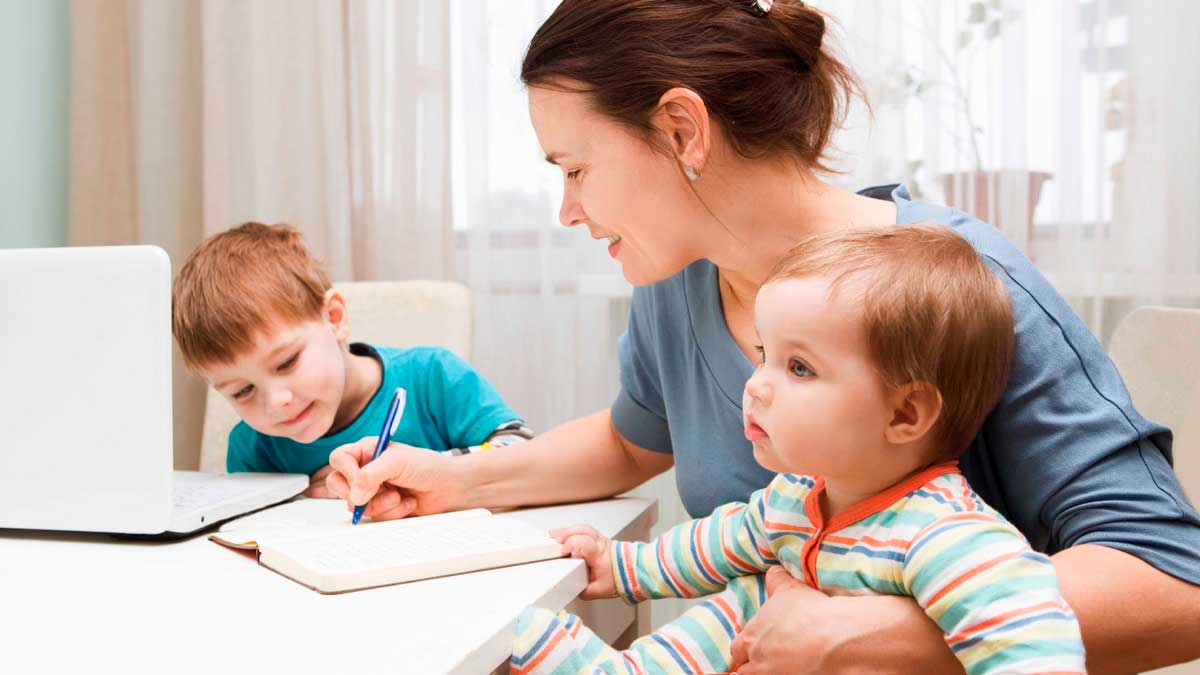 Madre con hijos usando ordenador, conciliación laboral en municipios andaluces