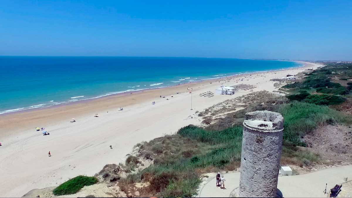 Vista panorámica de la playa de La Barrosa en Chiclana, ideal para camping y actividades al aire libre