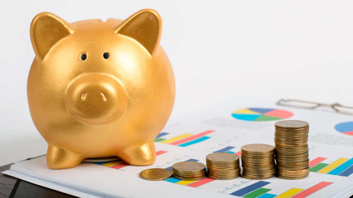 Cuenta remunerada combinada: hucha dorada y monedas sobre gráficos financieros