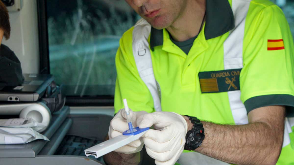 Agente de la Guardia Civil prepara un test de alcoholemia durante un control de tráfico en Andalucía.