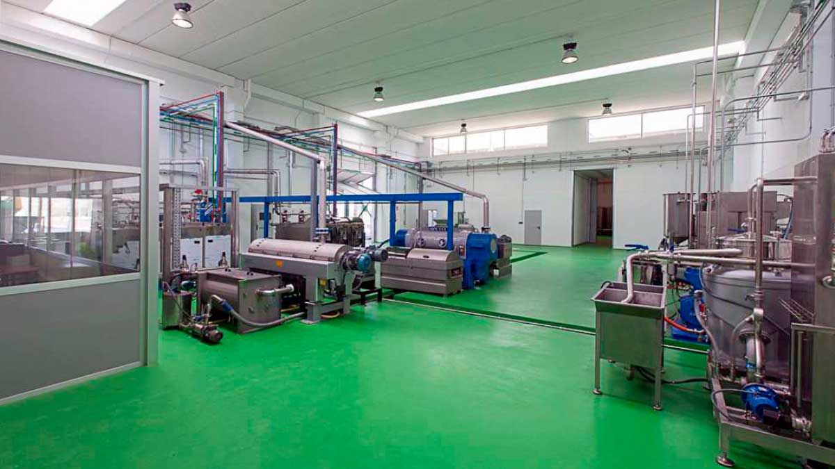 Sala de maquinaria en almazara moderna con equipos para el uso de enzimas en la producción de aceite de oliva