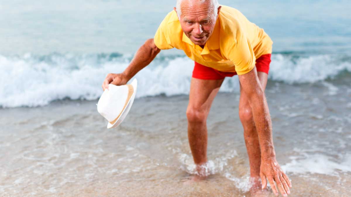 Hombre mayor disfrutando en la playa para reducir la ansiedad y la tensión arterial