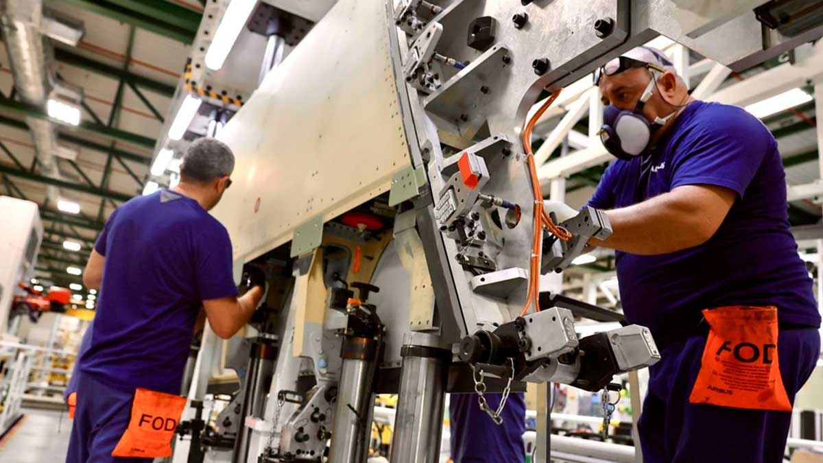 Trabajadores ensamblando componentes aeronáuticos en una planta de fabricación aeroespacial de Cádiz.