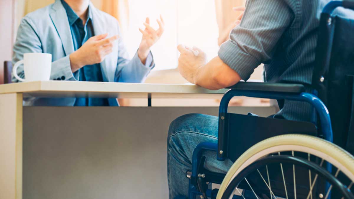 Consulta sobre incapacidad permanente sin trabajar en 2026 entre profesional y persona en silla de ruedas