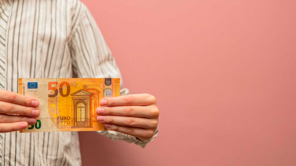 Persona sostiene un billete de 50 euros, relacionado con el Ingreso Mínimo Vital en Andalucía