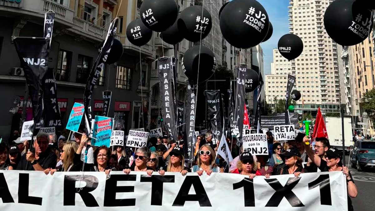 Manifestación sobre la Pasarela al RETA con pancartas y globos en una calle concurrida